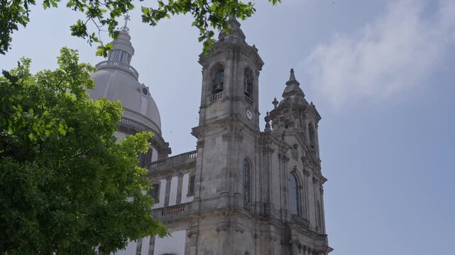 Sameiro Sanctuary bell tower and dome rising above green trees in Braga Portugal