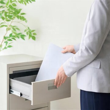 書類を引き出しにしまう支援者