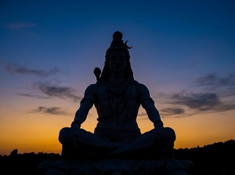 Shiva statue silhouette rests in a meditative pose against a glowing sunset sky.