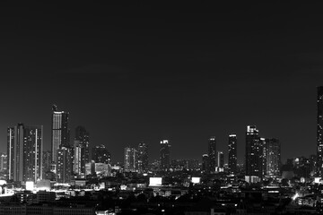 Fototapeta premium The high angle background of the city view with the secret light of the evening, blurring of night lights, showing the distribution of condominiums, dense homes in the capital community