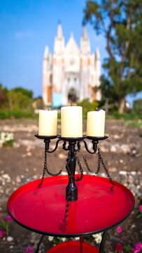 Red heart candle on stone wall with fairy lights.