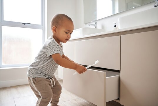 Child Opening Kitchen Cabinet And Learning Household Independence