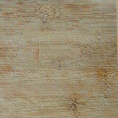 Fototapeta premium Close-up of a well-used bamboo cutting board surface, showing knife cut marks, wear, and natural grain texture.