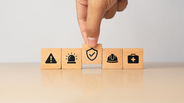 Work safety and compliance concept. Wooden cube blocks with icon of safety at workplace. Safety first, protections, health, regulations and compliance. Safety in working process. Zero accidents