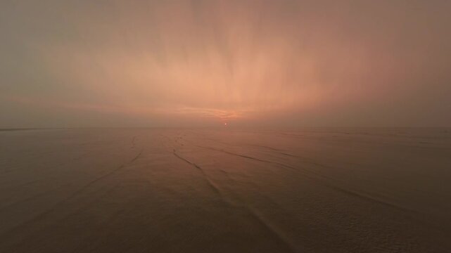 Drone view of sunrise morning in Nanhui Shanghai near sea, high angle view of waves on sea with red morning glow on blue sky, 1080P HD real time footage b roll shot.