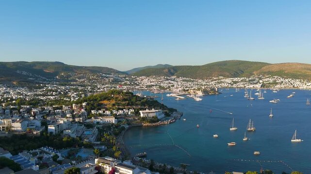 Bodrum, Turkey. Aerial view of the 15th-century Castle of St. Peter rising from a rocky promontory, its stone walls and towers commanding the marina and turquoise Aegean waters at golden hour. Aerial