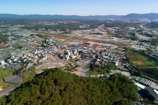 Stunning landscape showcasing the colorful town nestled between green hills, with patches of agricultural land stretching towards the horizon
