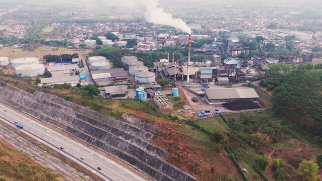 Aerial drone view of an industrial fuel storage terminal in Indonesia, featuring large storage tanks, pipelines, loading facilities, and supporting infrastructure for petroleum products and energy dis