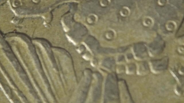 Macro close up of a spinning coin featuring an engraved eagle metallic surface detailed texture circular motion and reflective finish on a rotating currency coin