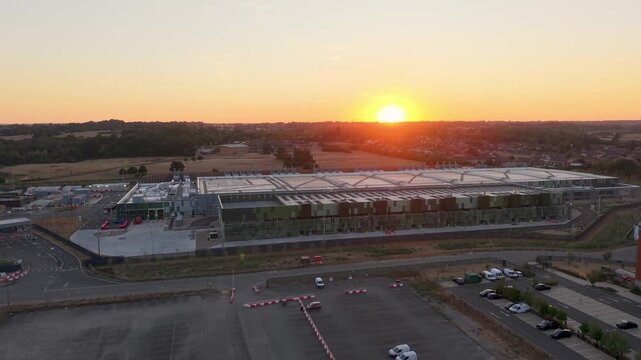 Google data centre flyover at sunset in Waltham Cross, Hertfordshire, UK. Drone advances over vast industrial campus near fields, highlighting land use, energy demand, and environment impact.