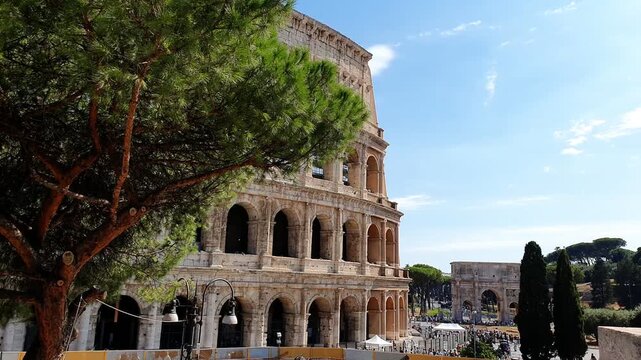 Colosseum and Arch of Constantine in Rome Italy showing ancient Roman architecture stone arches cypress trees and visitors near the historic monuments