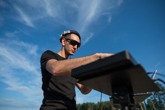 Caucasian man works as a DJ on the beach. 