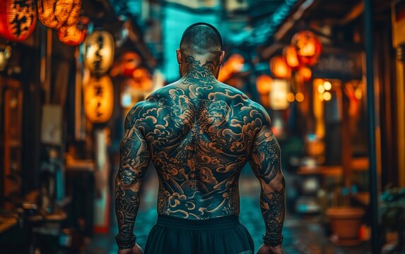 A man with intricate tattoos walks through a traditional Japanese street with paper lanterns.
