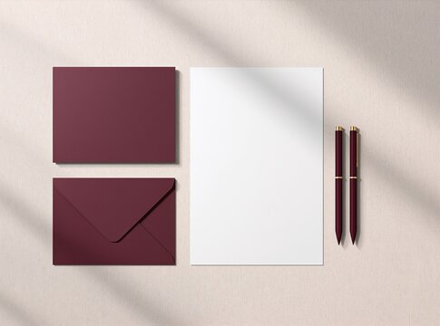 Elegant burgundy stationery set with an open envelope, card, blank A4 paper, and two pens on a cream background.