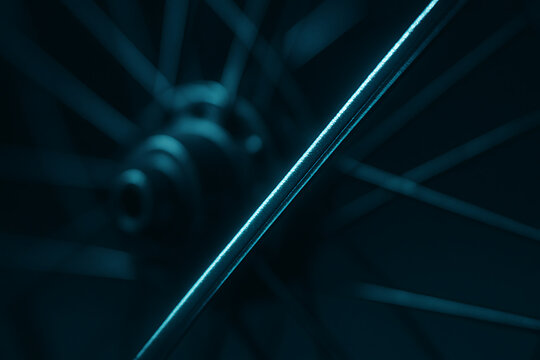 Abstract blue bicycle wheel spokes in dramatic close up with selective focus and moody lighting
