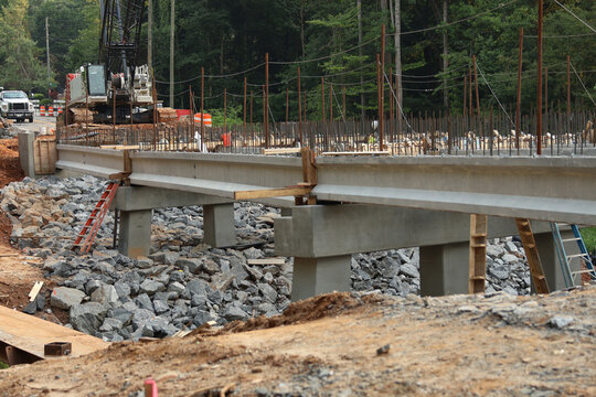Bridge construction. A construction site featuring reinforced concrete beams and a steel rebar framework during the erection of the bridge structure.