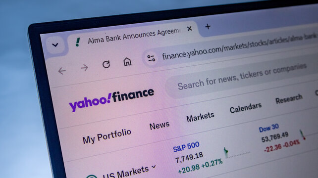 Yahoo finance website displaying stock market news and financial data on digital monitor.