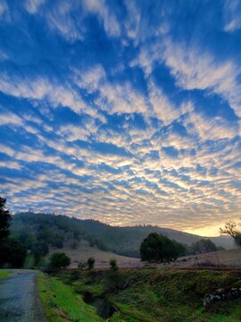 Dramatic Clouds With Golden Sunrise Over Rolling Hills