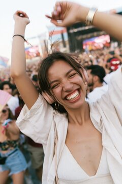 Woman dancing energetically at a summer music festival, natural joyful expression with headphones and a hand fan for entertainment and event branding