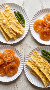 Traditional Gujarati Fafda and Jalebi on Paper Plates with Fried Green Chilies