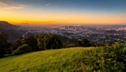 Fototapeta premium Sunset over green hill cityscape view.