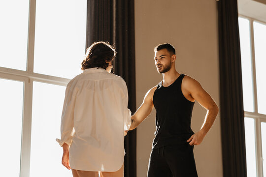 Two dancers shaking hands in a contemporary dance studio