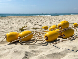 Tangled pile of yellow safety buoys on beach shore water rescue equipment © Bankerok