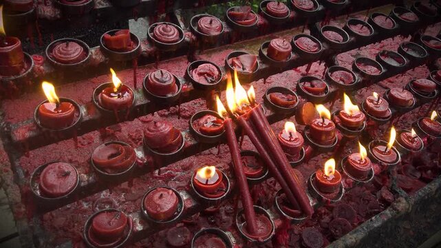 Burning Red Candles Wet of Rain - Catholic Christian Church Yard Outdoor - Prying and Memorial Ritual - Stormy Rainy Day or Night - Close Up 4K UHD