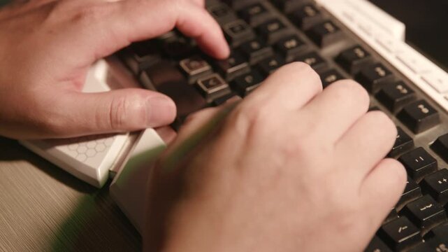 Close‑up of human hands typing on mechanical keyboard, office workspace background, computer work footage