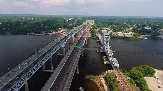 Aerial view of Gold Star Memorial Bridge spanning the Thames River with highway traffic and lush green surroundings in New London, Connecticut, United States.