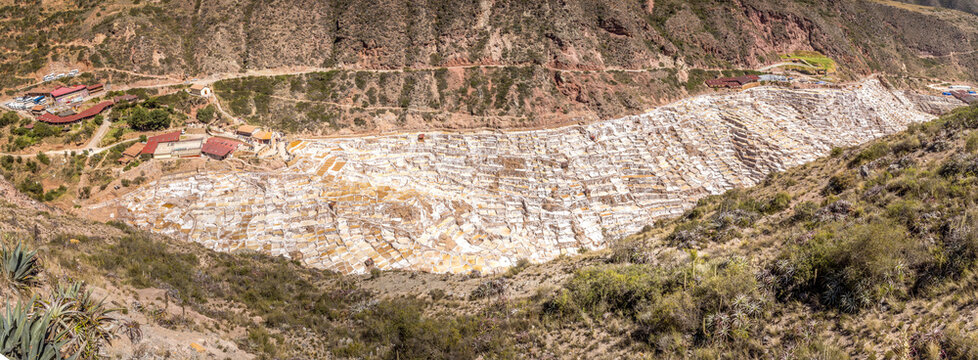 Extensive terraced salt ponds of Salineras de Maras spreading across the Andean mountainside with bright mineral colors and dramatic Sacred Valley scenery