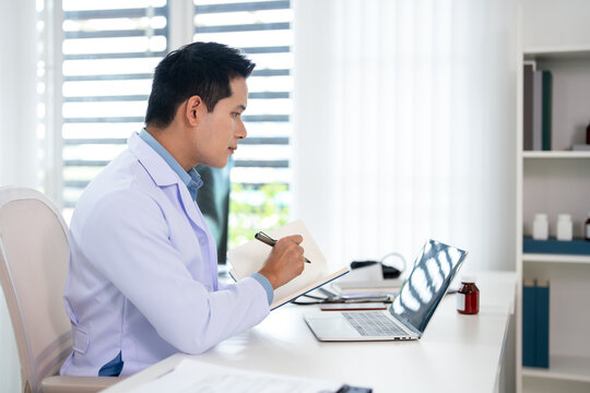 Doctor writing on a notepad in medical office.