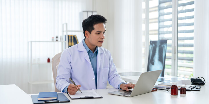 Doctor working on laptop in medical office.