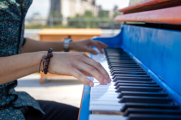 Close up of hands playing an outdoor colorful street piano © kodai