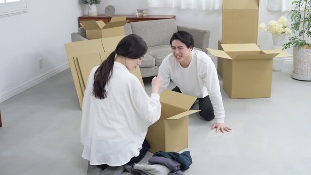 謝る夫と引越しの荷造りをする妻・夫婦喧嘩