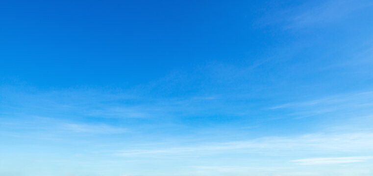 Clear blue sky with wispy clouds stretches above