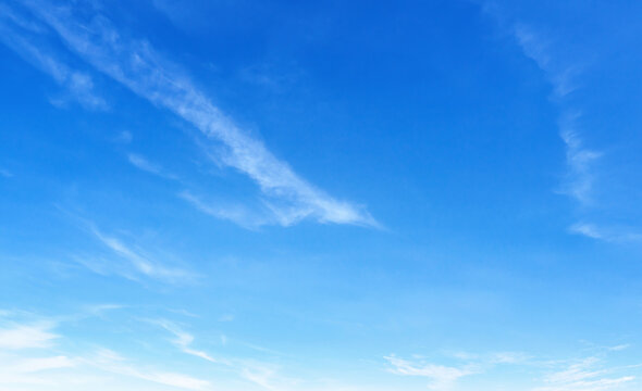 Clear blue sky with wispy clouds drifting gently