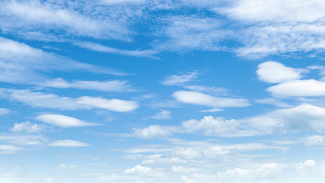 Clear blue sky with soft, wispy clouds