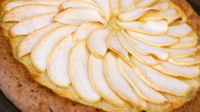 A delightful apple dessert. A pie made from raw apples in the process of being prepared.