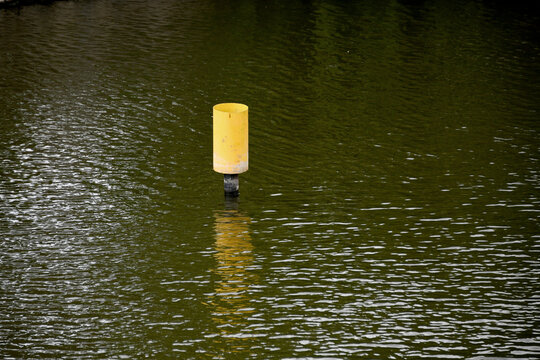 Yellow buoy floating on dark water, Prague, Czech Republic