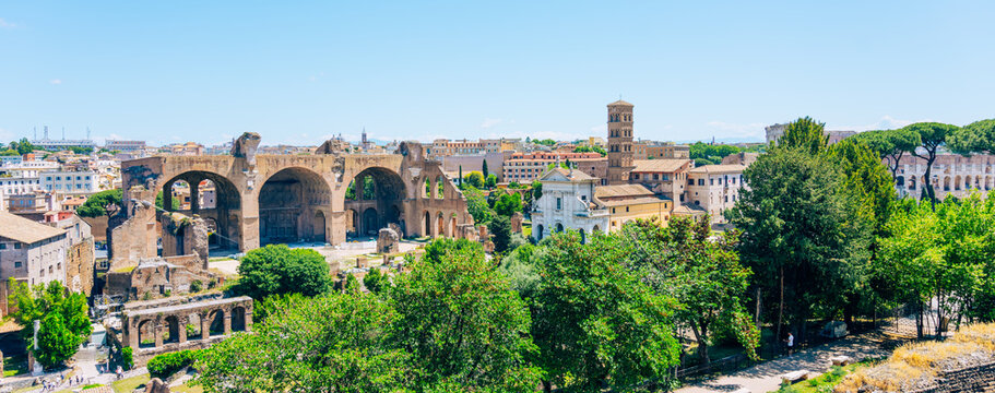 Visitors walk through the Roman Forum in Rome, Italy, surrounded by ancient ruins and trees. The sun shines down on the historic site filled with rich history and culture.