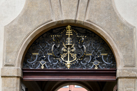 Arched church entrance with a stained glass window above wooden doors, Prague, Czech Republic