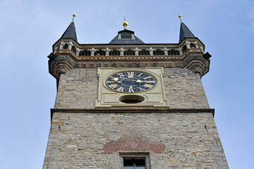 Low-angle view of the Gothic Old Town Hall Tower featuring a golden clock face in Prague's Old Town Square. © IbrahimAlkan