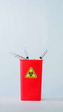 Red biohazard container storage holds hazardous medical waste syringe needles showing cautious danger warning for safety