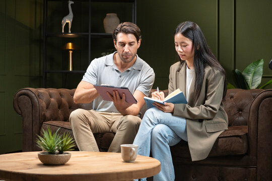Diverse business professionals sharing ideas and making notes during an informal meeting