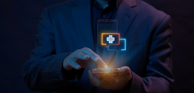 Businessman using smartphone touchscreen displaying glowing medical healthcare cross consultation chat icon. Mobile telemedicine consultation service and electronic healthcare messaging concept.