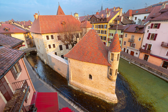 Palais de l'Ile surrounded by canal water and historic buildings in central Annecy, France.