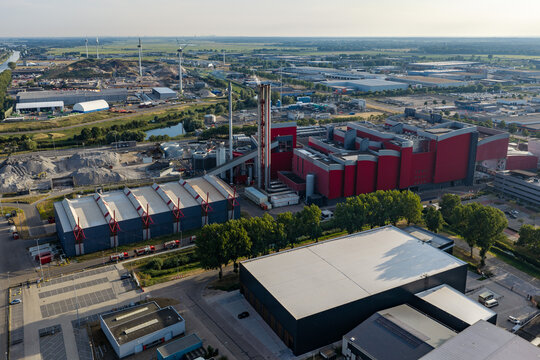 Aerial view of the HVC waste-to-energy plant with its distinctive red industrial buildings, tall chimney, and surrounding infrastructure in Alkmaar, Noord-Holland, Netherlands.