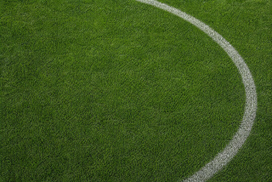 Green soccer field grass with white curved line, overhead view of football pitch turf, athletic sports stadium background