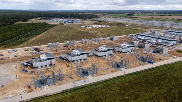 Aerial view of Baltica 2 Onshore Substation under construction with power transformers, electrical equipment, and surrounding forest landscape in Choczewo, Poland.